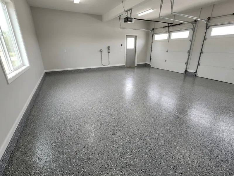 Two-car garage slab finished with a grey flake floor coating and a clean cove edge