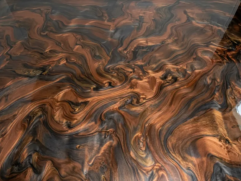 Metallic epoxy floor with swirled copper and charcoal pigment under a gloss topcoat